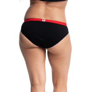 Culotte menstruelle bikini noire avec élastique rouge, vendues avec trois serviettes amovibles pour flux légers à flux abondants. Vue de derrière