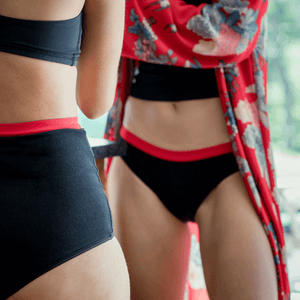 Culotte menstruelle bikini noire avec élastique rouge, vendues avec trois serviettes amovibles pour flux légers à flux abondants.